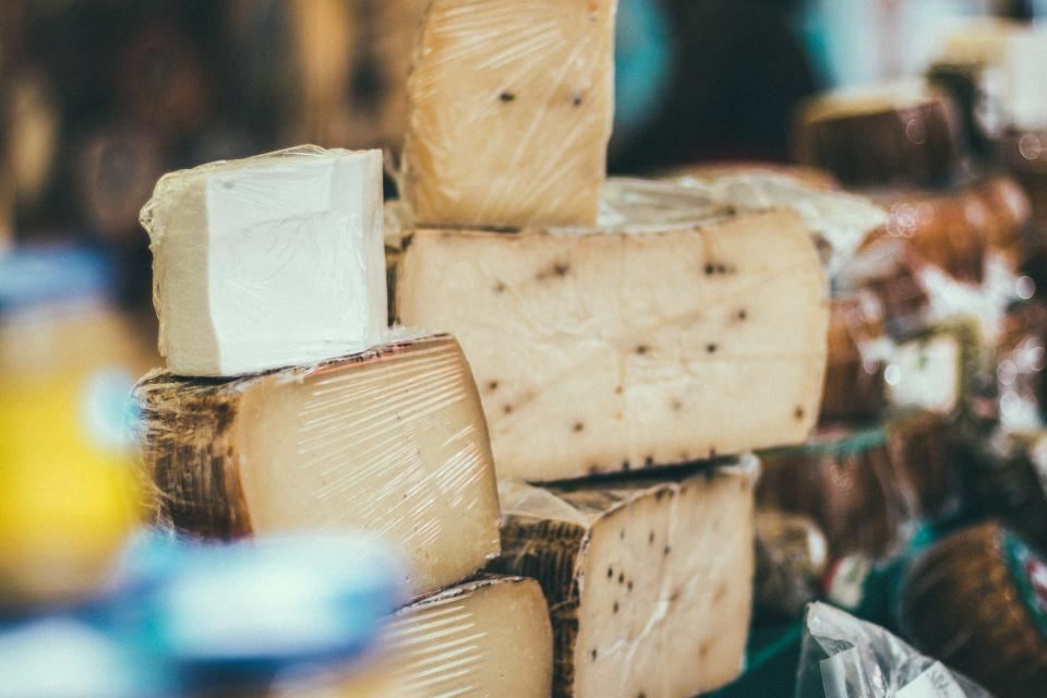 Gestapelte Laibe gereifter Käse an einem Marktstand